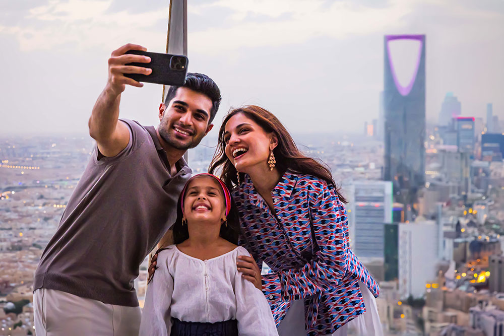 Eine Familie macht ein Selfie vor der Stadt Riad.